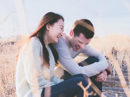 A happy couple laughing together on their first date. 