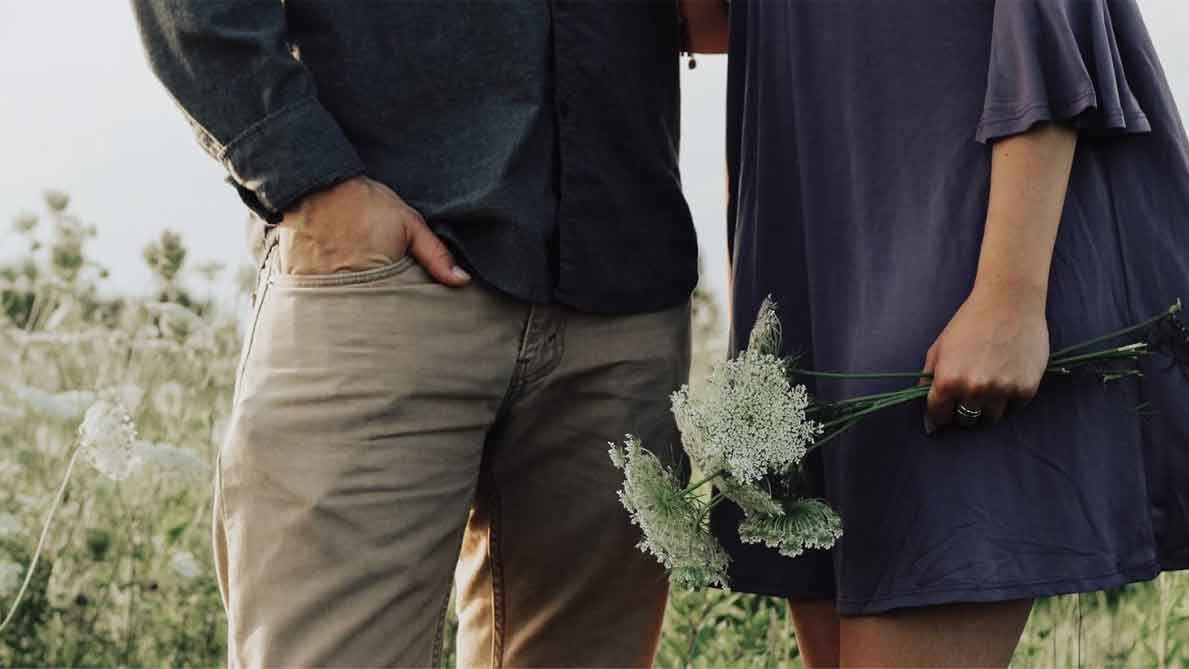 A photo of a man and a woman on a flower field